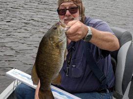 Guest Holding Small Mouth Bass Catch